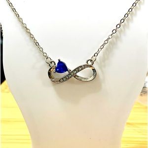 silver infinity pendant with blue stone